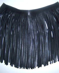 a black leather skirt with fringes on it