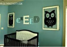 a baby's room with blue walls and an owl decal on the wall