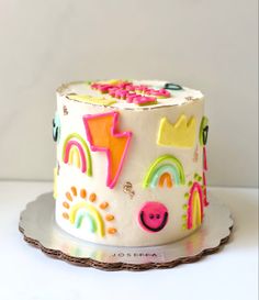 a white cake with rainbow decorations on it