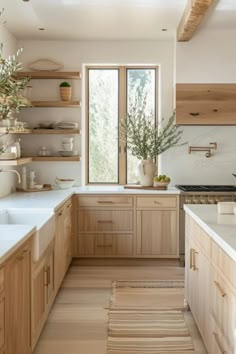 Bright modern kitchen with wooden cabinets, open shelving, and a large window over the sink. Dapur Skandinavia, Organic Modern Kitchen, Light Wood Kitchens, Wooden Countertops, Organic Kitchen, Simple Organic, Oak Kitchen, Scandinavian Kitchen, Kitchen Inspiration Design