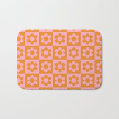 an orange and pink flower pattern bath mat