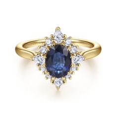 a yellow gold ring with an oval blue sapphire surrounded by white diamonds