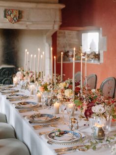 a long table is set with candles and flowers for a formal dinner or wedding reception