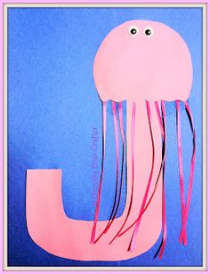 a paper cut out of a jellyfish on a blue background with pink ribbon and eyes