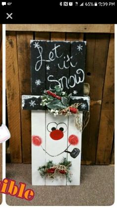 a snowman made out of pallet wood with the words let it snow written on it