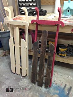 two wooden sleds sitting next to each other on top of a workbench