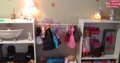 a doll house with clothes and toys in it's closet, next to a sink