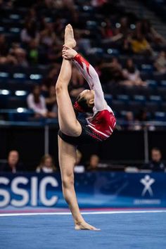 a woman is doing a handstand on the floor in front of an audience