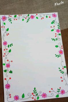 a paper with flowers and leaves painted on the bottom is sitting on top of a table