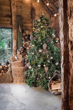 a small christmas tree is in the corner of a room with logs and other decorations