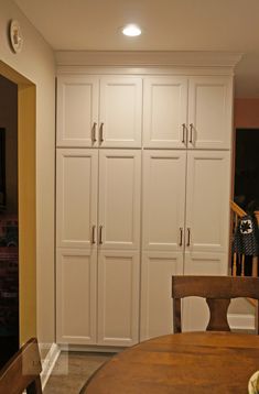 a dining room table and chairs with white cabinets