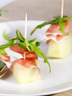 small appetizers are arranged on a plate with toothpicks and garnishes