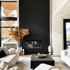 a living room filled with furniture and a fire place next to a large window on the wall