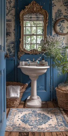 a bathroom with blue and white wallpaper has a pedestal sink in the corner, along with wicker baskets on the floor