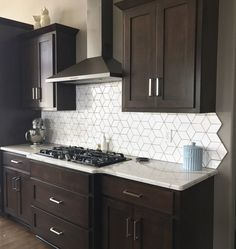 a kitchen with dark wood cabinets and white tiles on the backsplash is shown