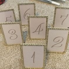 the table numbers have been placed in squares with gold sequins on them for display