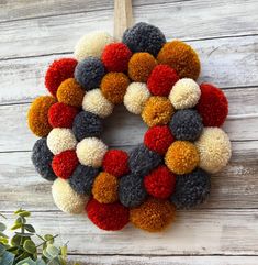 a multicolored wreath hanging on a wooden wall