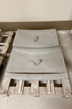 two pieces of concrete sitting on top of pallets next to each other in a room