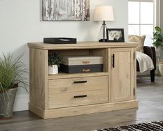 an entertainment center in a living room next to a couch and table with a lamp on it