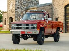 a red truck parked in front of a brick building