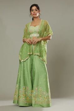 Green apple candy raw silk sharara cum palazzo, hand embroidered with cutdana and colorful sequins in floral pattern. Comes with embroidered padded bustier, hand embroidered bohemian kaftan and belt.
Component: 4
Pattern: Hand Embroidered
Type Of Work: Floral Appliques, Sequins Cutdana
Neckline: Sweetheart
Sleeve Type: Batwing Sleeves
Fabric: Raw Silk, Silk Organza
Color: Green
Other Details: 
Floral patters
Adjustable bustier straps
Back smocked bustier
Scalloped hem kaftan
Approximate product Green Apple Candy, Silk Sharara, Apple Candy, Palazzo Pant, Palazzo Set, Gowns For Girls, Indian Fashion Designers, Silk Organza, Floral Applique