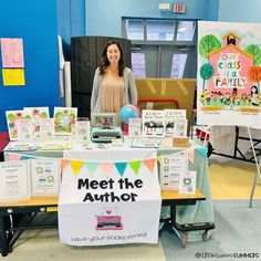 a woman standing in front of a table filled with books and pamphlets for children's crafts