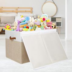 a large box filled with stuffed animals in a living room next to a couch and mirror