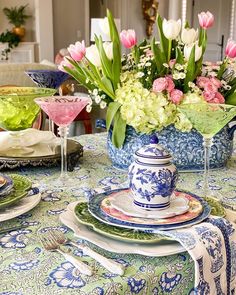 a table topped with plates and cups filled with flowers