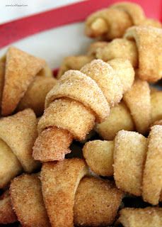 a pile of sugared donuts sitting on top of a white and red plate