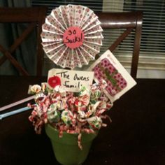 a green pot filled with lots of candies next to a sign that says the queen's tamer