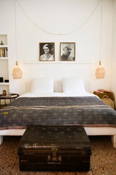 a bedroom with a large bed and two pictures on the wall