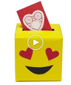 a yellow box with red hearts and a card in the shape of a smiley face