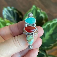 This triple stone ring has lots of fun colors going on with both green and blue turquoise and a deep orange carnelian.  She is a vibrant statement piece with a rustic vibe.  I gave her sterling silver bead accents and a textures sterling split shank band. Measurements:  47mm x 16mm Ring Size:  8.5 Turquoise is known as the master healing stone.  Attributed to the power of connecting mind, body, and soul, it is also a symbol of superior energies and spiritual openness. Known as an artist's stone, the Carnelian crystal is a warm, vibrant stone that boosts confidence and the power of true expression.  This stone empowers your self-confidence in all aspects of your life - from relationships and professional pursuits to personal projects. When you are searching for a stone to help you tap into Unique Multicolor Oval Gemstones, Oval Multicolor Rings For Collectors, Oval Multicolor Rings For Collectible, Multicolor Oval Fusion Rings, Unique Three-stone Ring Jewelry, Multicolor Multi-stone Fusion Rings, Spiritual Carnelian Multicolor Jewelry, Southwestern Style Multicolor Oval Rings, Adjustable Multicolor Multi-stone Turquoise Ring