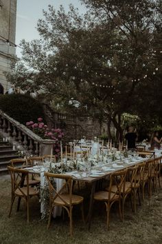 an outdoor dining table set up with flowers and candles