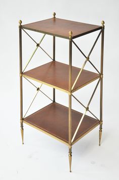 three tiered metal shelf with wood top and brass trimmings on the sides