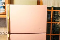 a pink refrigerator freezer sitting next to a window