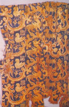 an old piece of cloth with gold and blue designs