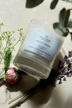 Midsummer candle by Wild Planet Aromatherapy lying on side next to white and pink flower and lavender sprigs Essential Candles, Relaxing Candles, Essential Oil Blend, Aromatherapy Candles