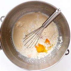 a metal bowl filled with batter and eggs