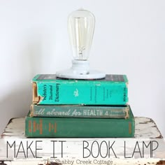 three books stacked on top of each other with a light bulb sitting on top of them