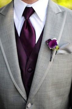 a man in a gray suit with a purple flower on his lapel