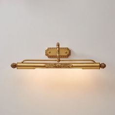 a bathroom light that is gold in color and has two lights on each side of it