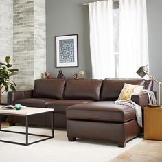 a living room filled with furniture and a fire place in front of a brick wall