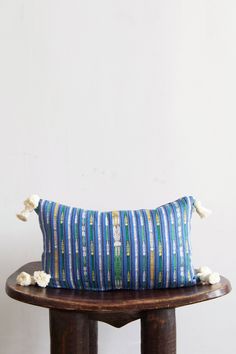 a blue striped pillow sitting on top of a wooden table