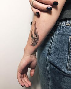 a woman's arm with a bird tattoo on it