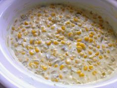 a white bowl filled with corn on top of a table