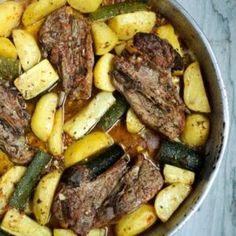 a pot filled with meat and vegetables on top of a table