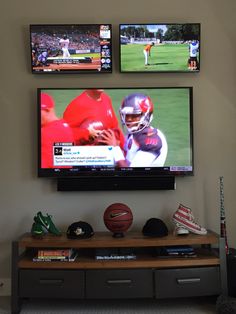 a flat screen tv mounted to the side of a wall above a wooden entertainment center