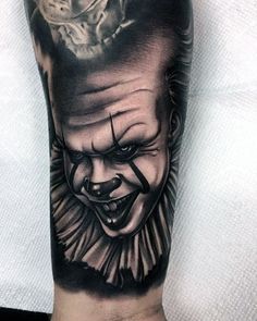 a man's arm with a creepy clown tattoo on it