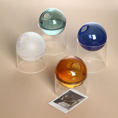 three glass vases sitting on top of a table next to an empty photo album